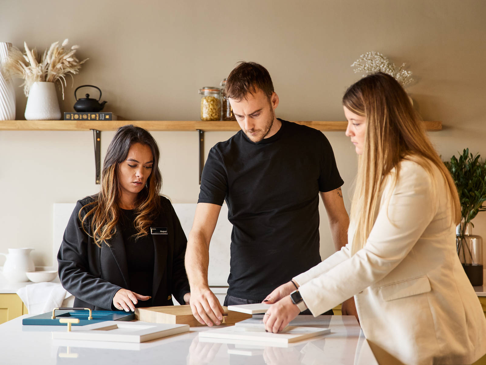 Magnet kitchen designer and Trade customers discussing samples in a display kitchen at Magnet Store