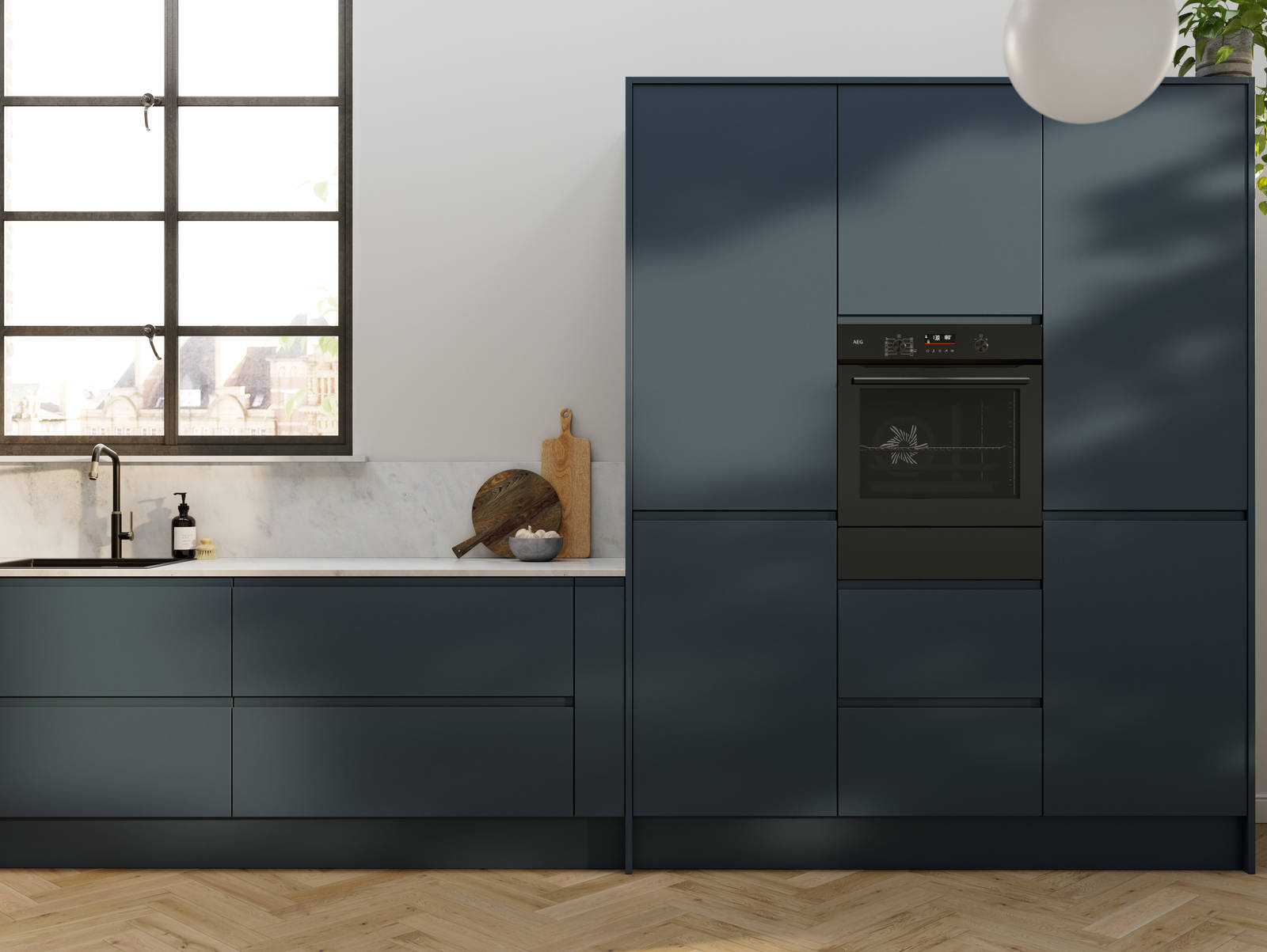 Contemporary and minimalist handleless kitchen with J-Pull door in dark blue shade Mineral Blue, with marbled worktop and matching upstand, herringbone wood flooring.