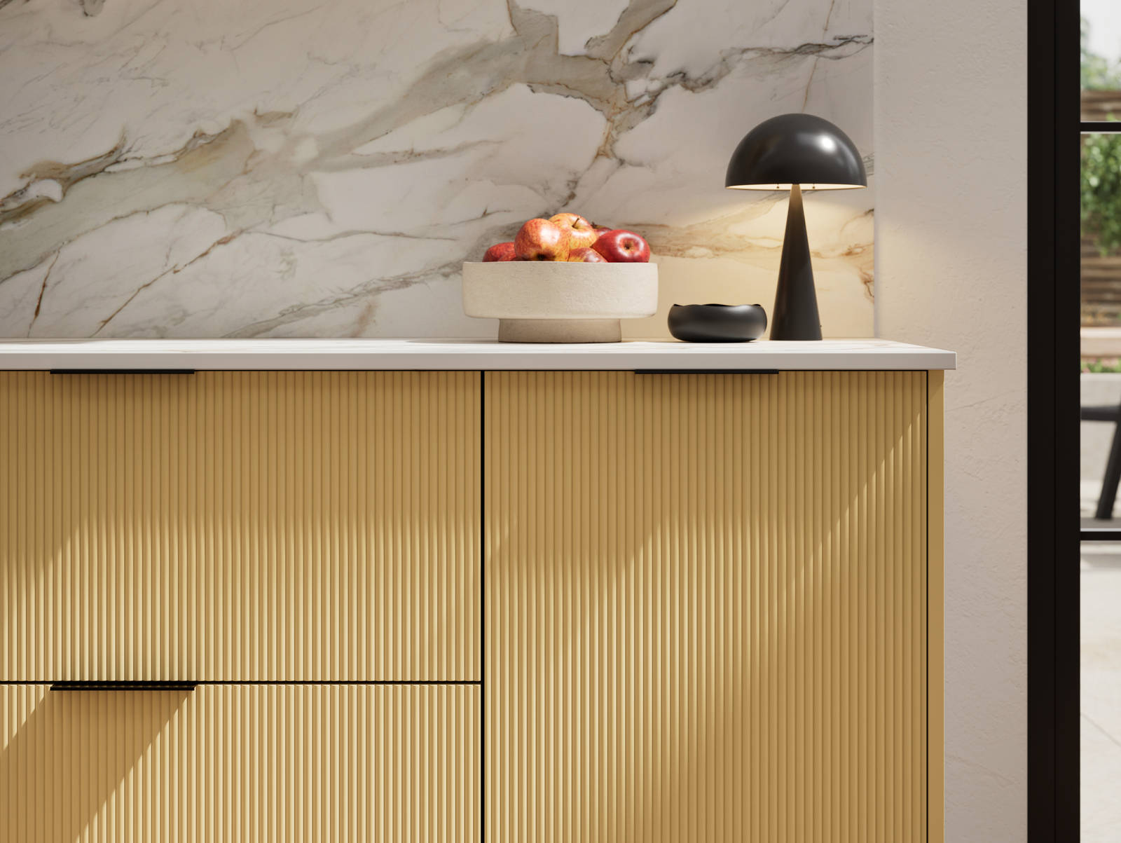 Fluted front kitchen Reed from Magnet in bright yellow shade Harvest, with a marbled splashback and black handles, herringbone wood flooring.