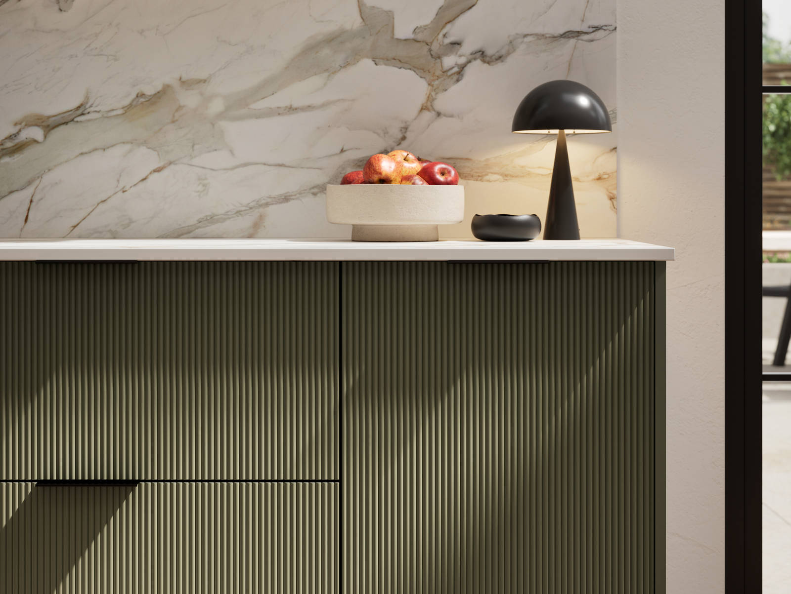 Fluted front kitchen Reed from Magnet in dark green shade Tailored Green, with a marbled splashback and black handles, herringbone wood flooring.