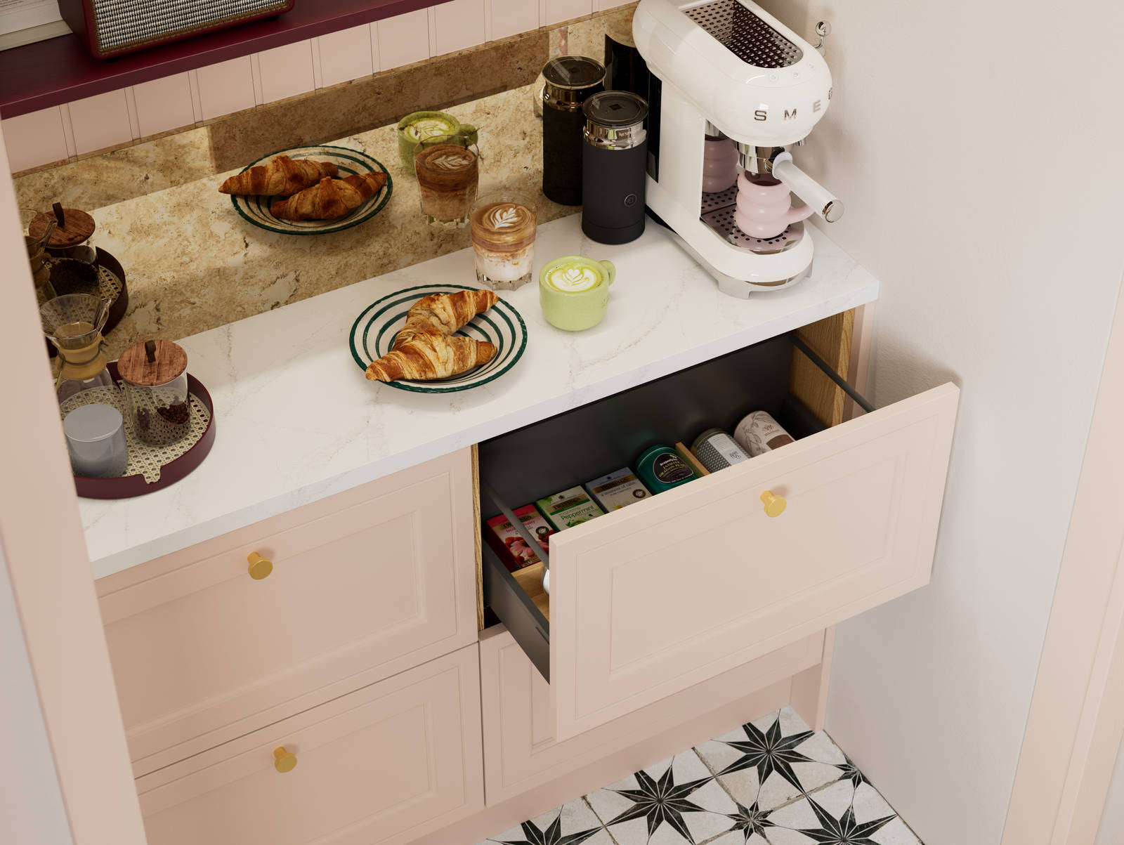 Opened drawer of teas in painted wood grain Shaker style Bewdley cabinets in light pink shade Chalk Blush, with marbled worktop, brass knobs and Smeg coffee machine on countertop.