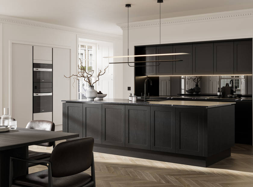 Handleless frame doors Integra Wardley Sumi black kitchen with kitchen island, Integra Soho Limestone tall cabinets with integrated ovens, black dining table and chairs, pale oak chevron flooring.
