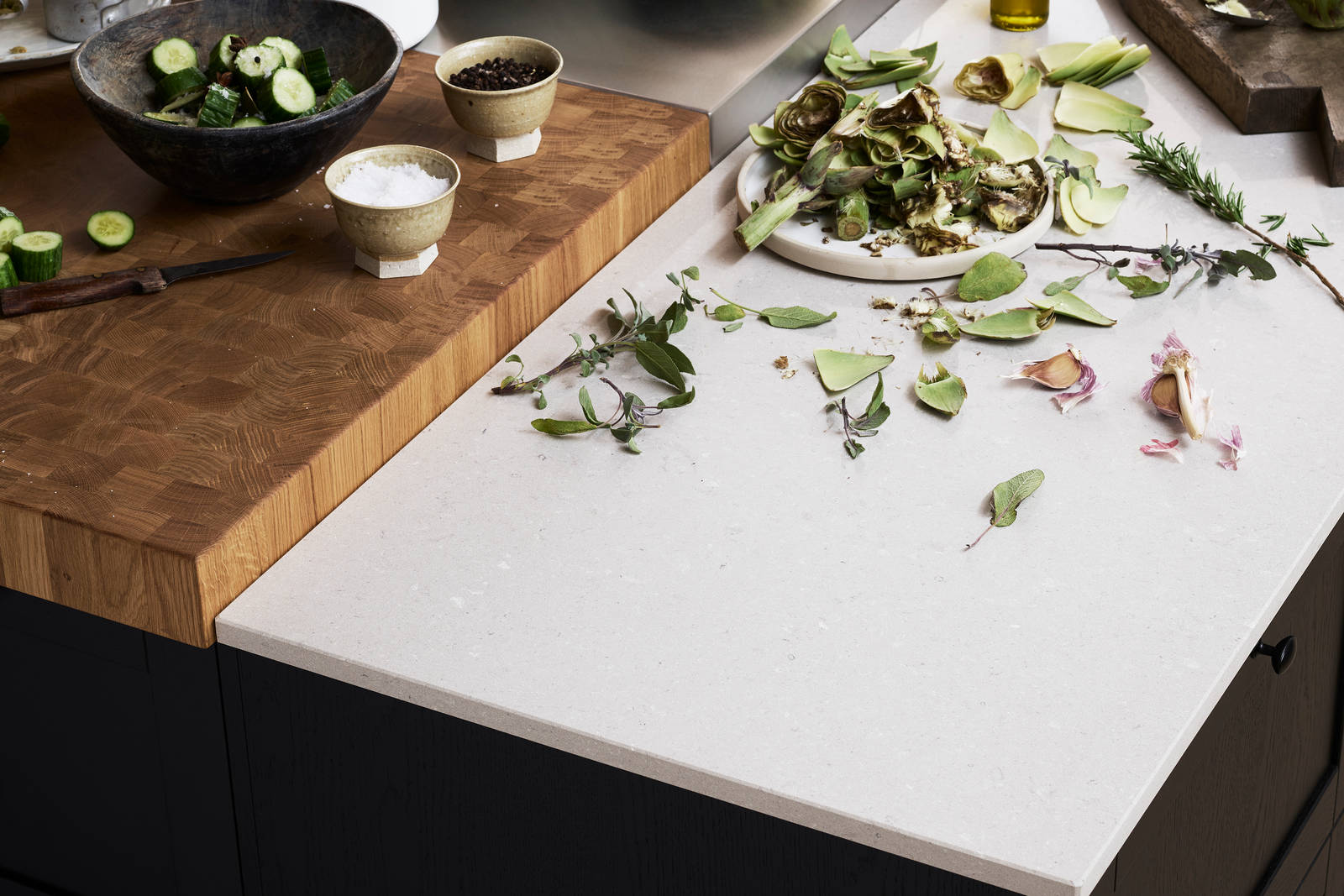 Ramsvik svarbets - Köksö  från Marbodal med bänkskivor i  tre olika material. Kvartkomposit med en centrerad del i rostfritt samt en nedsänkt huggkubbe.