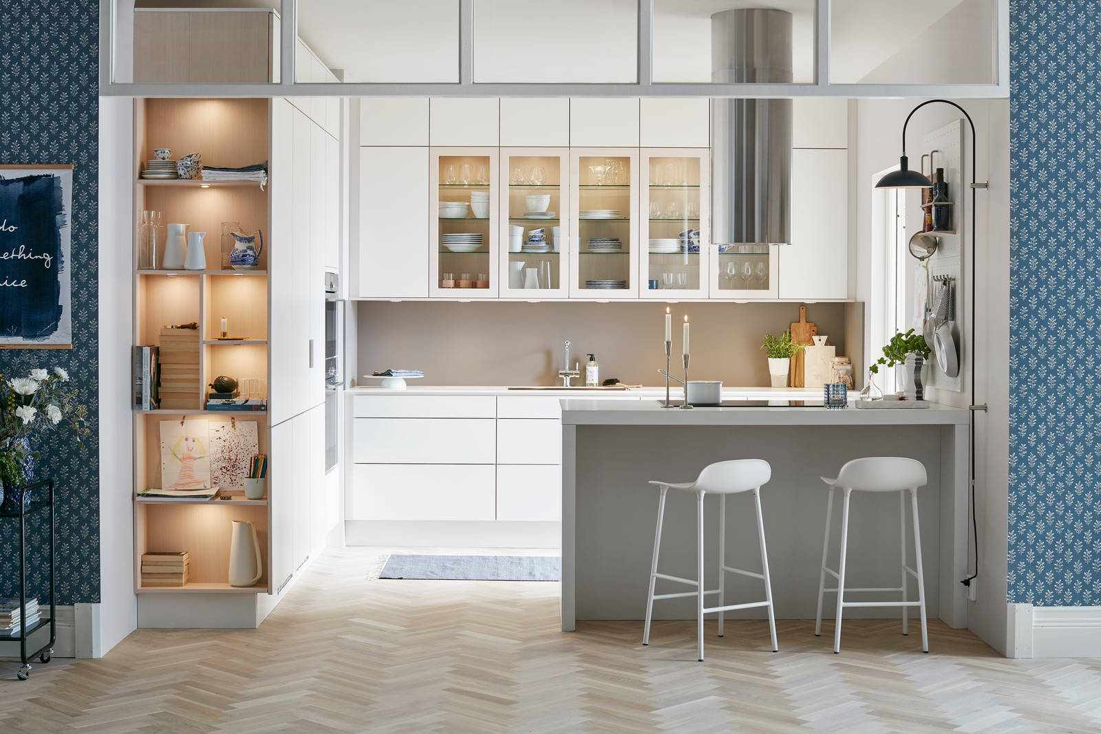 Marbodal Torö2 Frost - köklucka i högtrycklaminat med svagt rundad askkant. Vitrinlucka med fanerad ask. Handtagslöst kök med Mullvad stänkskydd i laminat ger köket en modern karaktär. Den öppna gavelhyllan med belysning blir fint blickfång från vardagsrummet.