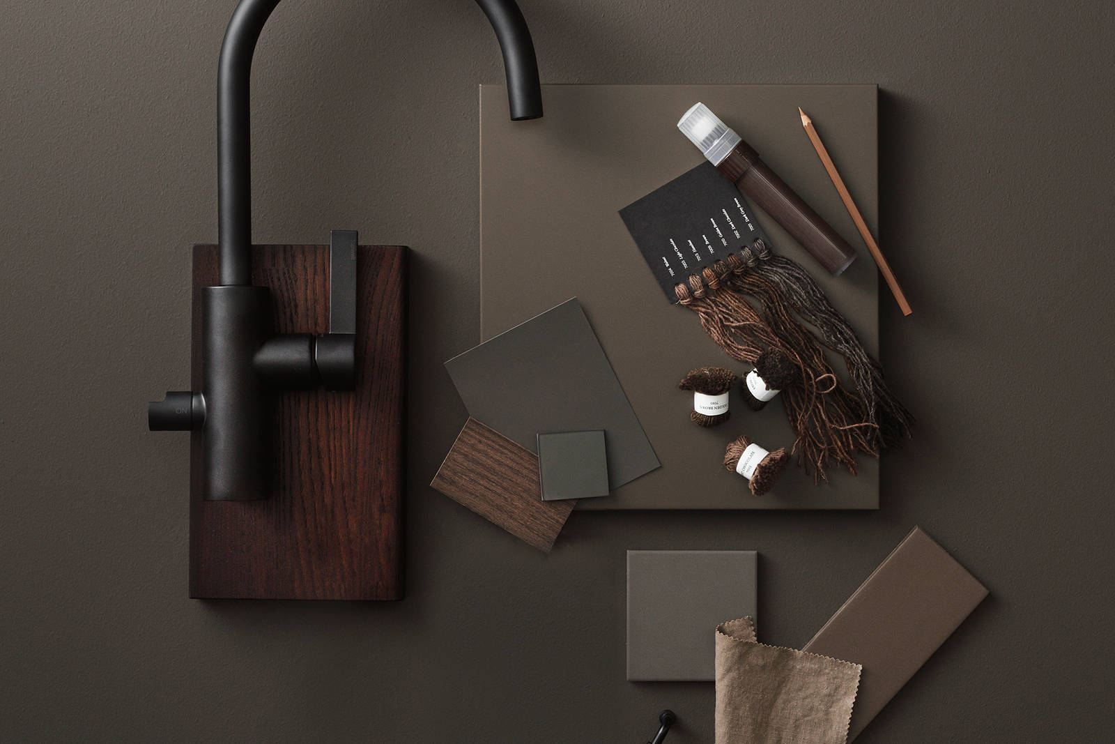 Slät brun kökslucka, slät kökslucka i brunbetsad ek, svart rundad blandare från tapwell, färgprover i naturmaterial