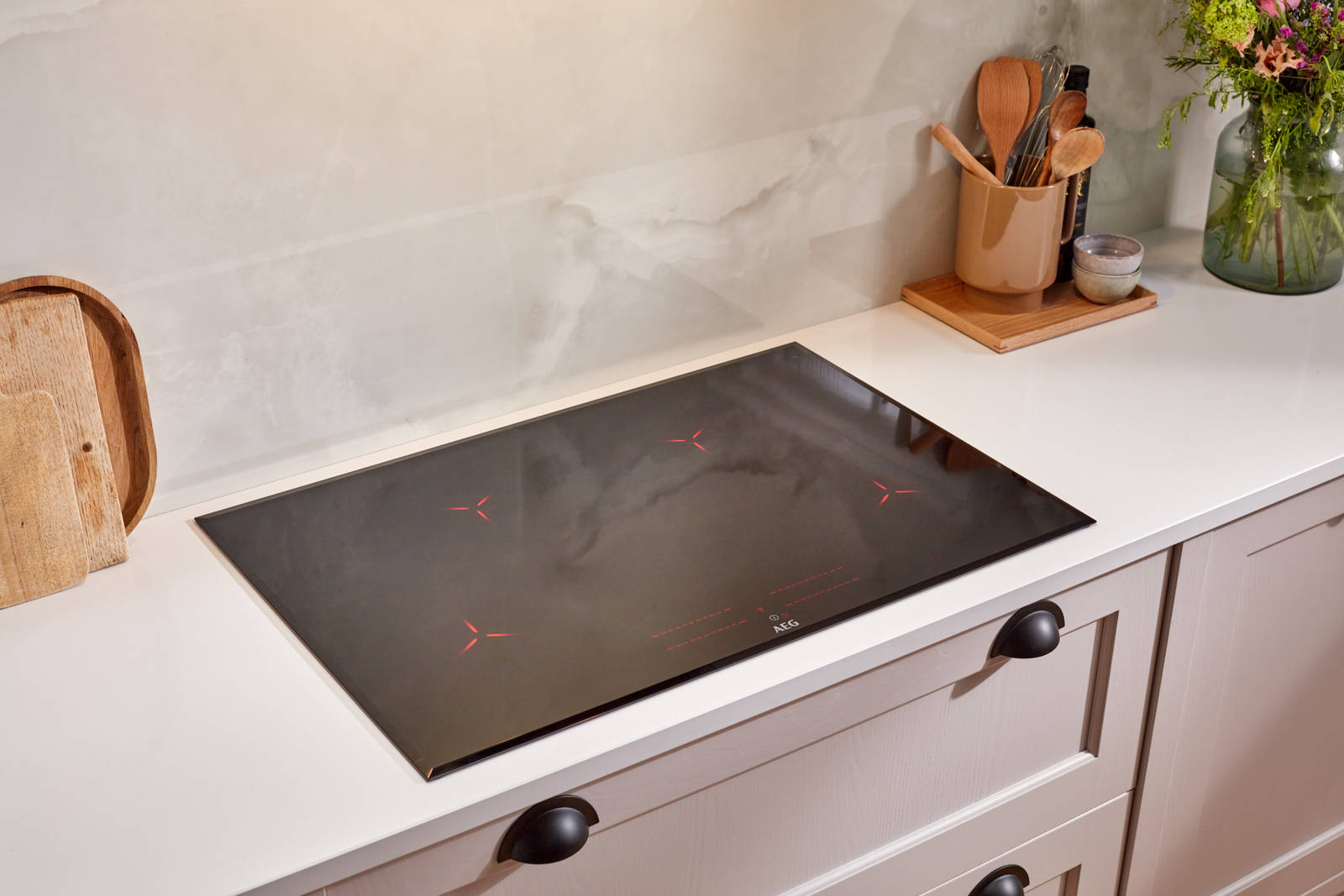 AEG induction hob in a neutral shade Shaker kitchen from Magnet, with a white worktop