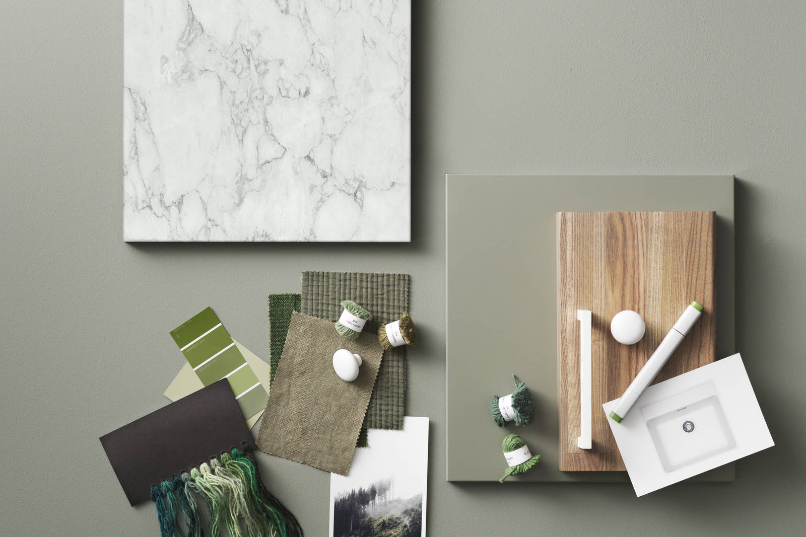 Moodboard med grøn køkkenlåge, marmor, grønne tekstiler og hvide greb