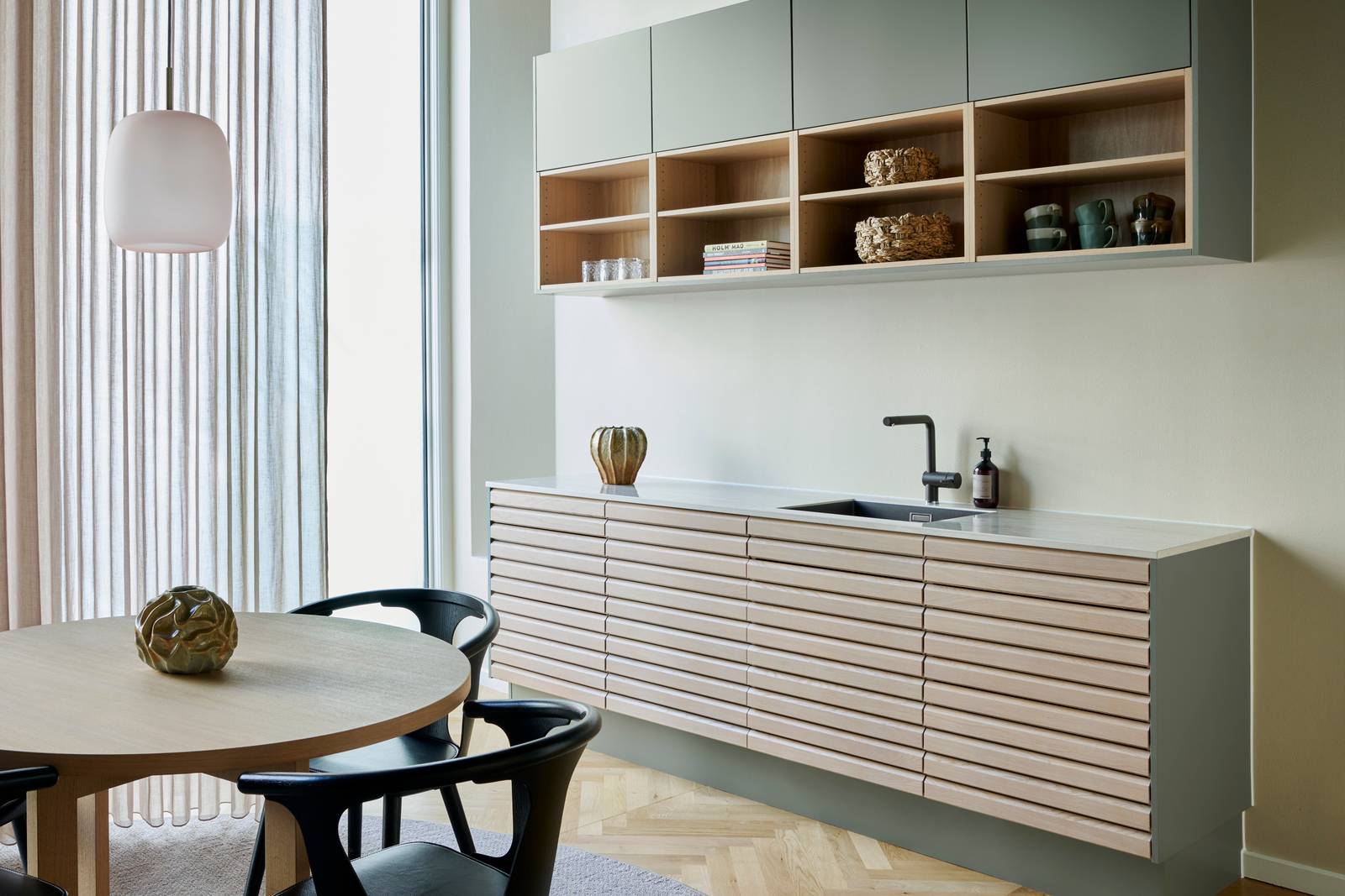 Egetræskøkken Ikon med håndsorterede lameller i massiv eg, kombineret med overskabe og åbne væghylder grebsfrie grønne køkkenet Highline Salvie med indfræsede greb i lågerne fra INVITA