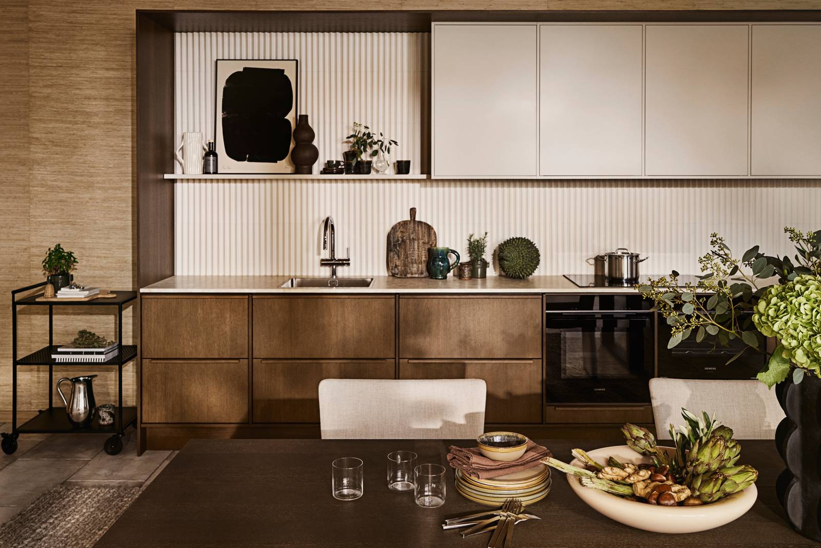 Mørk eg køkkenbænk Forever Oak fra INVITA kombineret med overskaber Athena Sand, hvide fliser, bordplade og massiv ek håndtag, ovn og dampovn fra Siemens