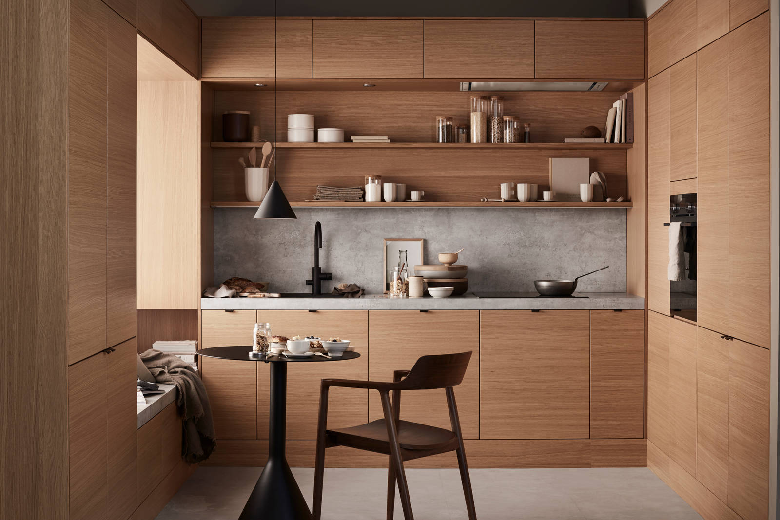 Finér eg natur køkken Athena fra INVITA i finér eg natur, med matchende væghylder, laminat bordplade og splashback med betonmotiv, sort håndtag, vandhane og vask