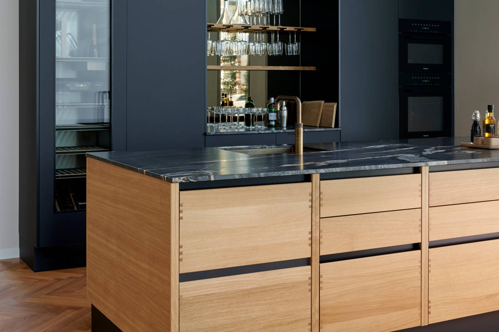 Køkkenøya Glød fra INVITA , skuffer i massivt egetræ med fingertappede samlinger og sort granit bordplade