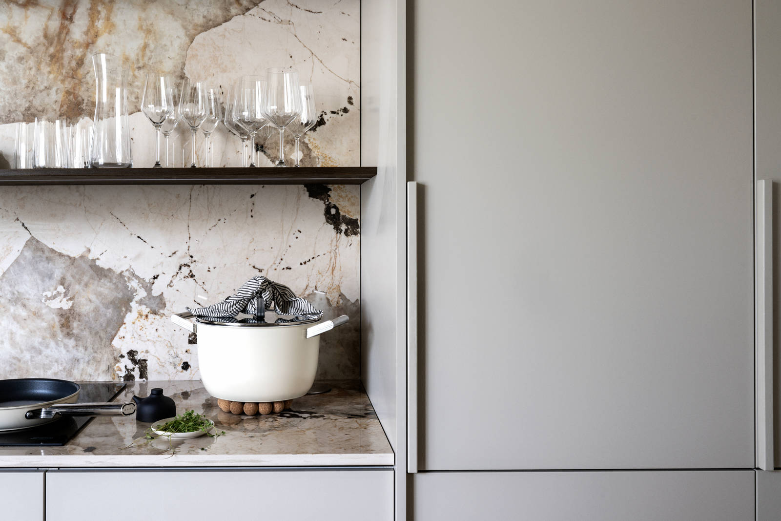 Köksbänk och högskåp i beige Arkitekt Plus Sand med vägghyllor i Signatur Ekbacken fanerad eklucka i brunbets från Marbodal, bänkskiva och stänkskydd som matchar.