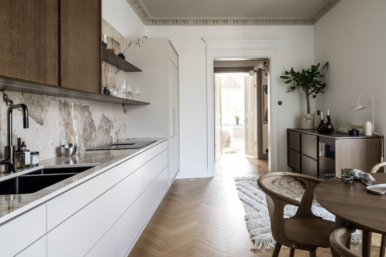 Kök med kombination av köksbänk i beige Arkitekt Plus Sand med överskåp i Signatur Ekbacken fanerad eklucka i brunbets från Marbodal, bänkskiva och stänkskydd som matchar och öppna vägghyllor i brunbetsad ekfanér.