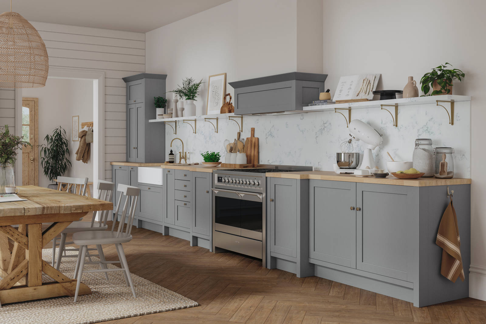 A grey Shaker kitchen seen with a wooden dining table and accessorised with plants.