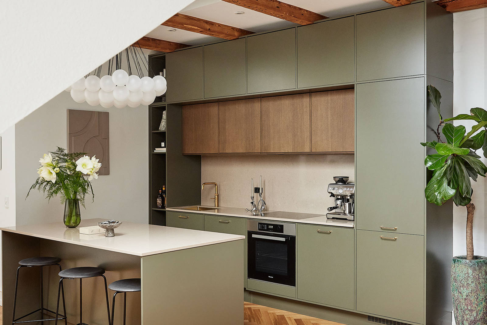 Grønt køkken med træskabe og køkkenø