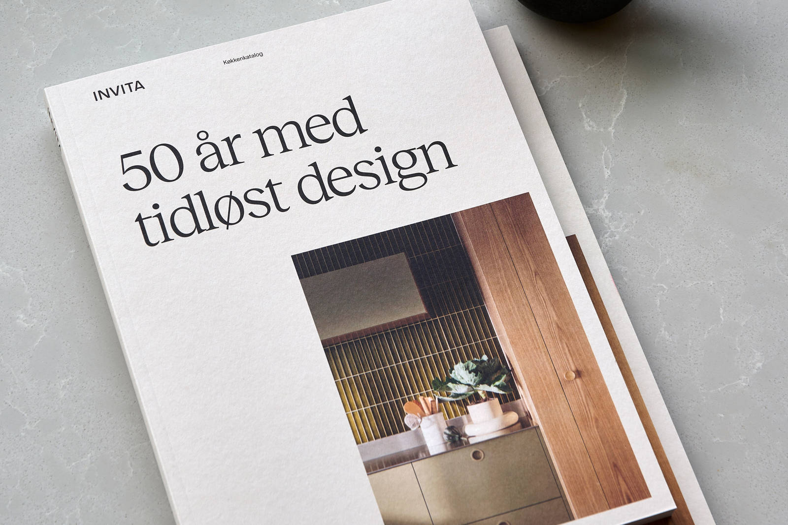 Katalog fra INVITA og kaffekop på bordet