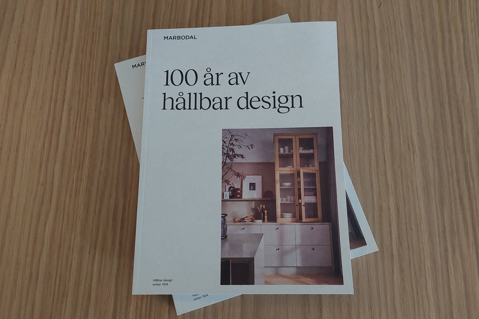 Två kataloger från Marbodal på ett träbord