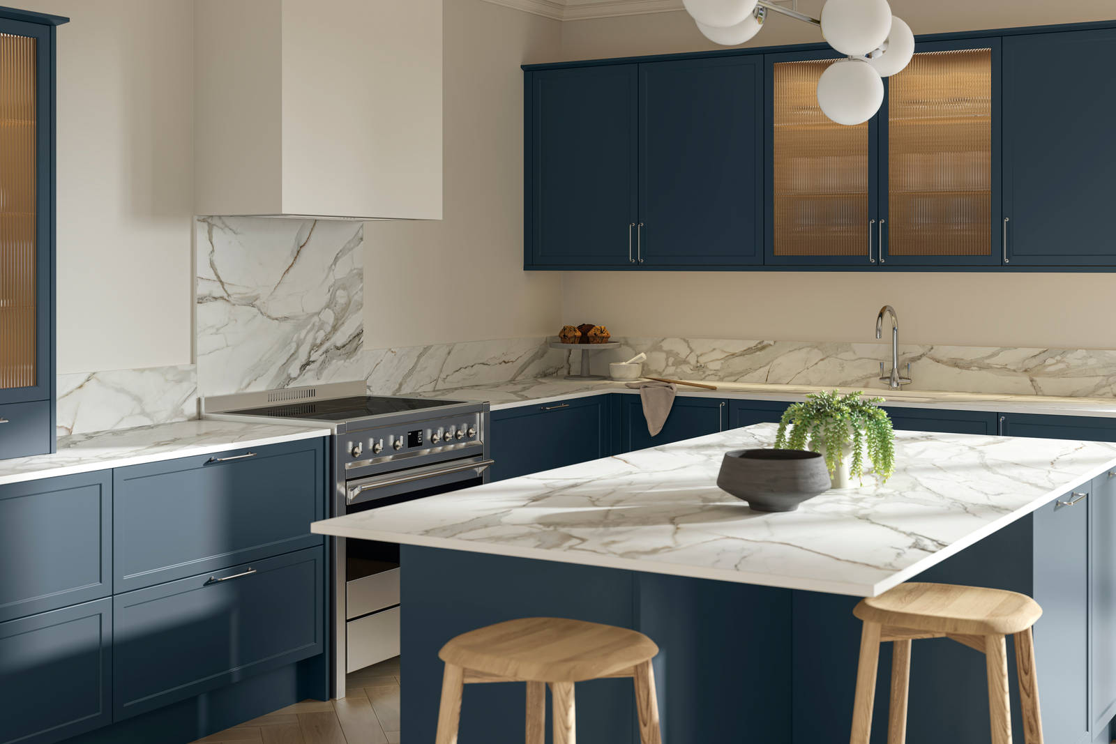 View over kitchen island breakfast bar in modern Shaker kitchen Brunswick Voyage blue with white and grey marbled worktop and matching splashback, and vitrine cabinets with fluted glass.