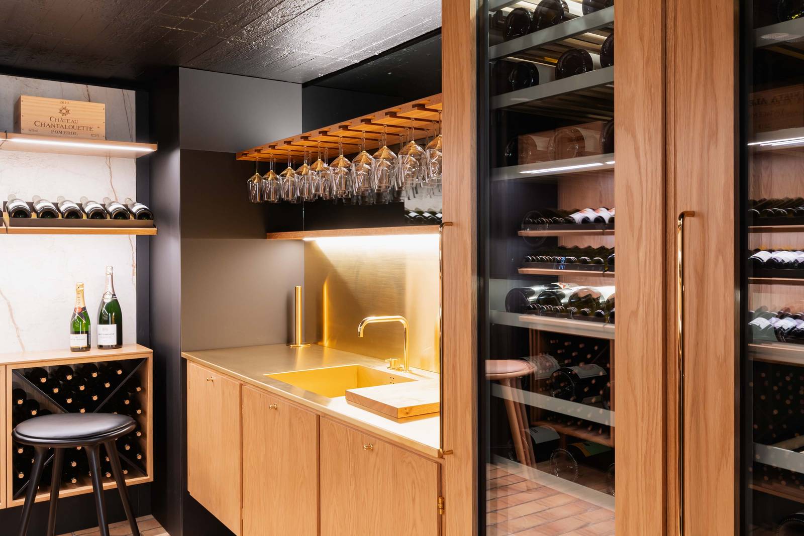 Vinkælder med vinskabe, fronter i egetræ og messingbordplade med håndlavet vask.