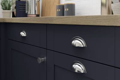 Close-up of Tatton Midnight kitchen from Magnet, a contemporary dark blue narrow frame shaker door, with steel handles and wood worktop.