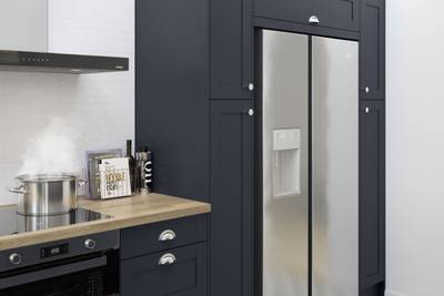 Tatton Midnight kitchen from Magnet, a contemporary dark blue narrow frame shaker door paired with a wood worktop and steel handles.