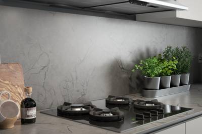 Close-up of hob on a grey and black marbled worktop and splashback in kitchen Integra Nova Grey by Magnet.