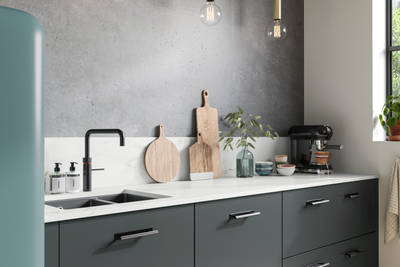 Soho kitchen in Arboretum Green with a blue Smeg fridge, black handles, tap and sink.