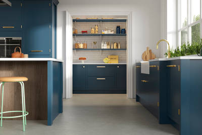 View of Soho Voyage Blue kitchen with brass accent details and pantry.