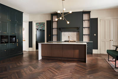 Ludlow, a traditional Shaker-style kitchen range in the shade Arboretum Green combined with a dark wood panel kitchen island