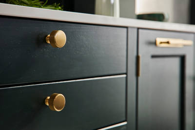 Ludlow, a traditional Shaker-style kitchen range in the shade Arboretum Green, combined with brass handles and knobs.