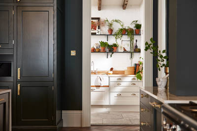 Ludlow, a traditional Shaker-style kitchen range in the shade Arboretum Green combined with a white utility room next door.