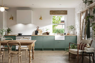 Soho Eucalyptus green open plan kitchen in contemporary cottage with a light wood dining table.