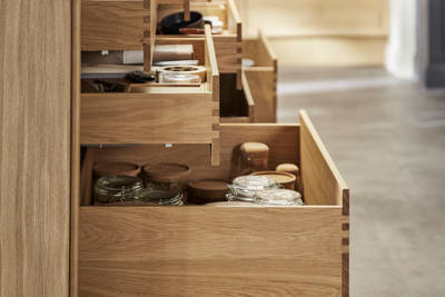 Side view of opened oak drawers in Nordic Craft kitchen island, drawers containing beautiful cookery ware.
