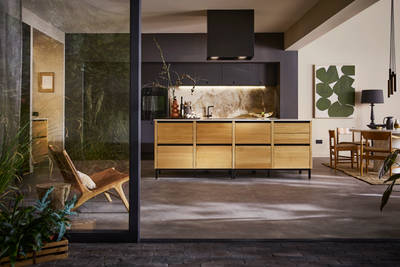 Open floorplan kitchen Mindful World, view from outside open glass foors to patio, with kitchen table and black ceiling-mounted Roroshetta Mantica Sense.