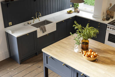 View of shaker kitchen in dark blue shade, with marble worktop and a kitchen island with light wood worktop.