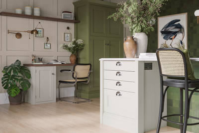 Off-white and olive green kitchen featuring shaker-style cabinetry and a desk area within the space.