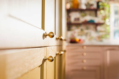 Close-up view of Douglas handles in Brushed Satin brass on Ludlow Harvest cabinets
