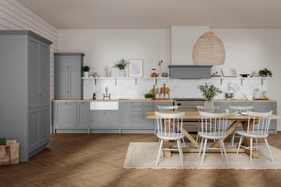 A contemporary home with a grey kitchen featuring white cabinets and wooden floors.