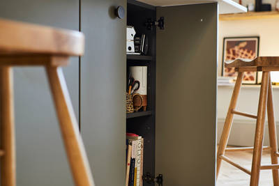 Close-up of opened cabinet in Soho Balmoral kitchen island, with light wood barstools