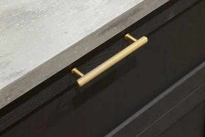 A close-up view of Ambleside drawer frontals in Graphite, with brass bar handles and grey worktop.