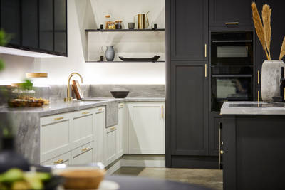 The Ambleside kitchen in Limestone and Graphite, paired with brass bar handles, a grey worktop and modern brass tap.