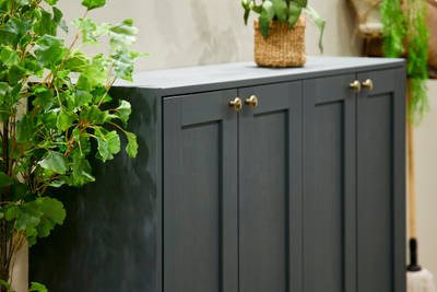 The Ambleside kitchen range in Fern, a dark shade of green, paired with brass handles.