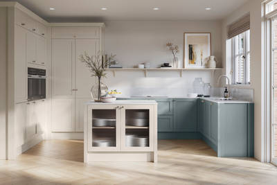 Open floorplan kitchen with small kitchen island in Wardley kitchen from Magnet in the light shade Limestone as well as blue Duck egg, decorated with flowers in glass vases and earth toned ceramics.