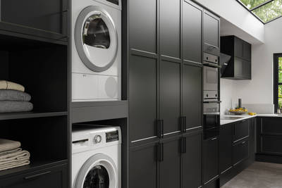 Integrated laundry machine and dryer, tall cabinets in black modern shaker Brunswick kitchen and laundry room.