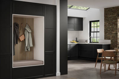 View from living room of closet section with bench, akupanel and coat hooks in modern shaker Brunswick Sumi Black cabinetry to match the kitchen.