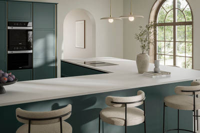 View of Georgian extension in handleless frame door Integra Brunswick Spruce G-shaped kitchen, with warm neutral decor, Minerva white worktop and splashback, breakfast bar with bar stool seating.