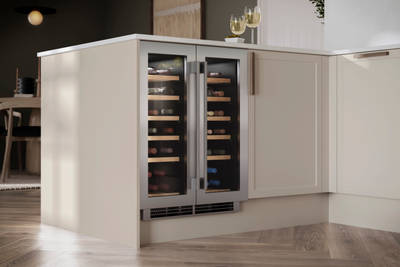Integrated Wine cooler Caple in Modern Shaker Brunswick Limestone kitchen with oak handles and light wood herringbone flooring.