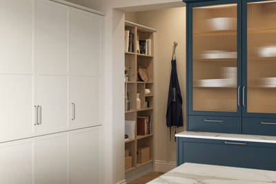 Corner of modern Shaker kitchen Brunswick Voyage Blue and Limestone with open light wood shelves, vitrine cabinet with fluted glass doors.