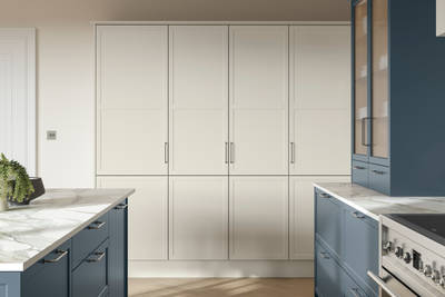 Modern Shaker kitchen Brunswick with kitchen island in shade Voyage Blue and tall cabinetry in shade Limestone, white and grey marbled worktop and steel handles.