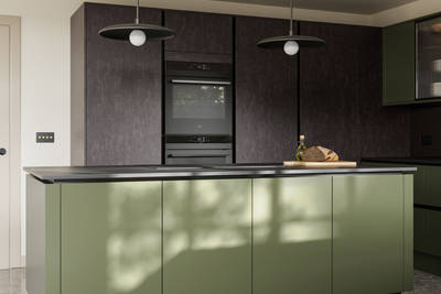 Integra Soho Tailored Green kitchen and kitchen island with contrasting dark wood Portobello Etna and black accessories, integrated ovens in tall cabinets, Dekton worktop and fluted glass vitrin wall cabinets.